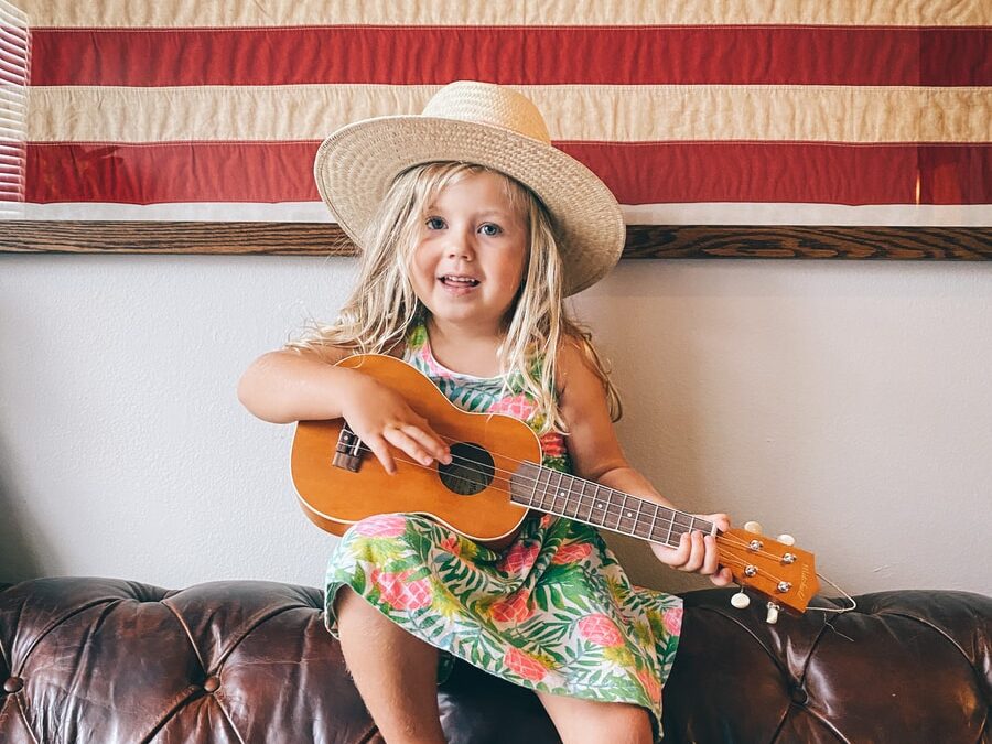 woman in brown cowboy hat and green dress sitting on black leather couch